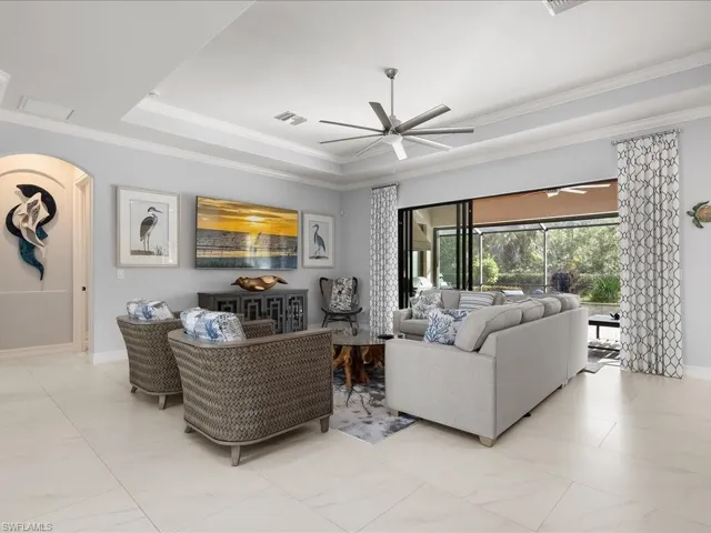 Living area featuring a tray ceiling, ceiling fan, and ornamental molding
