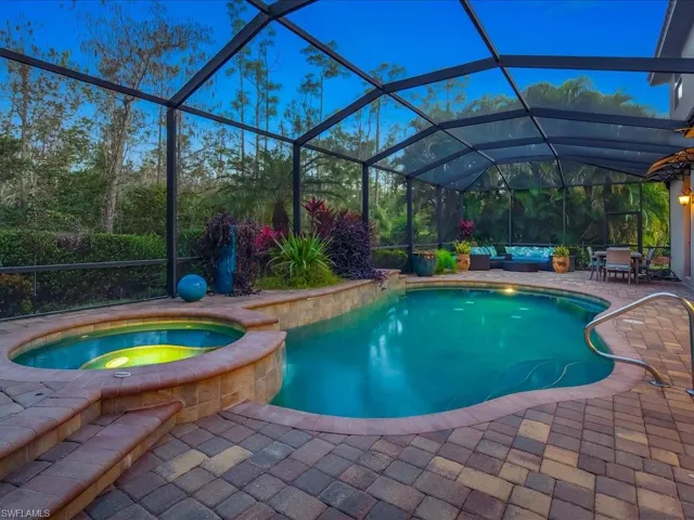 View of pool featuring a sunroom, glass enclosure, a patio area, and a pool with connected hot tub