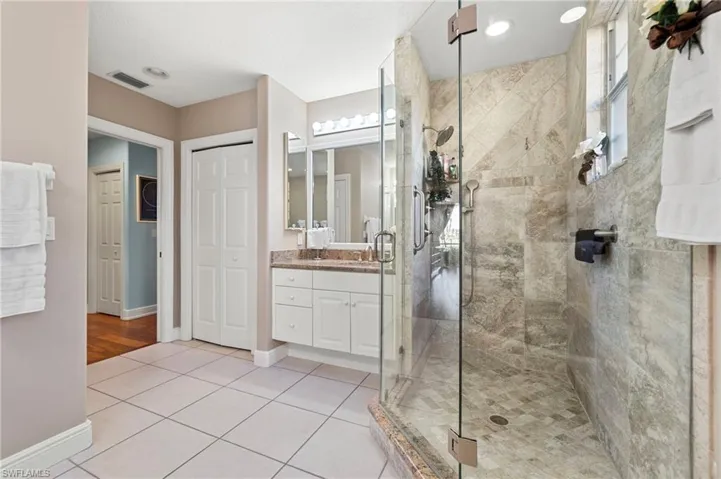 Bathroom with tile patterned flooring, vanity, and an enclosed shower