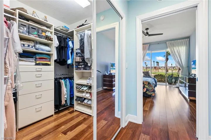 Walk in closet with hardwood / wood-style floors and ceiling fan