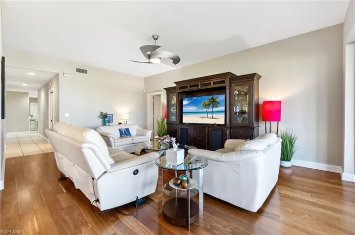 Living room with wood-type flooring and ceiling fan