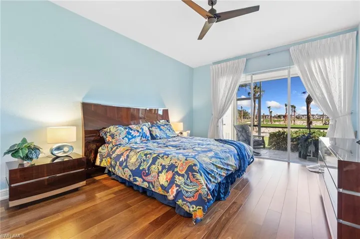 Bedroom with access to exterior, hardwood  floors, and ceiling fan
