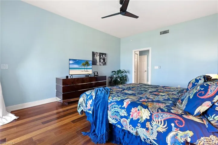 Bedroom featuring ceiling fan and dark hardwood / wood-style floors