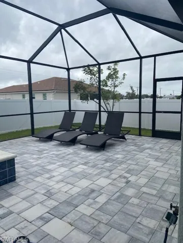 View of patio / terrace featuring a lanai and fence