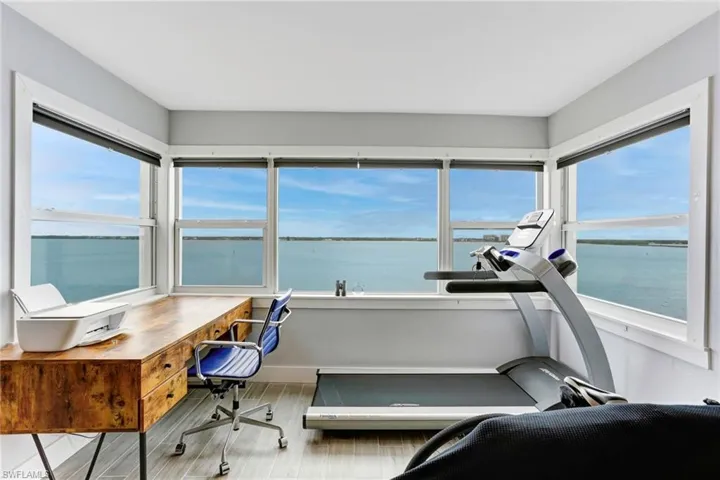 Office space with hardwood / wood-style floors and a water view