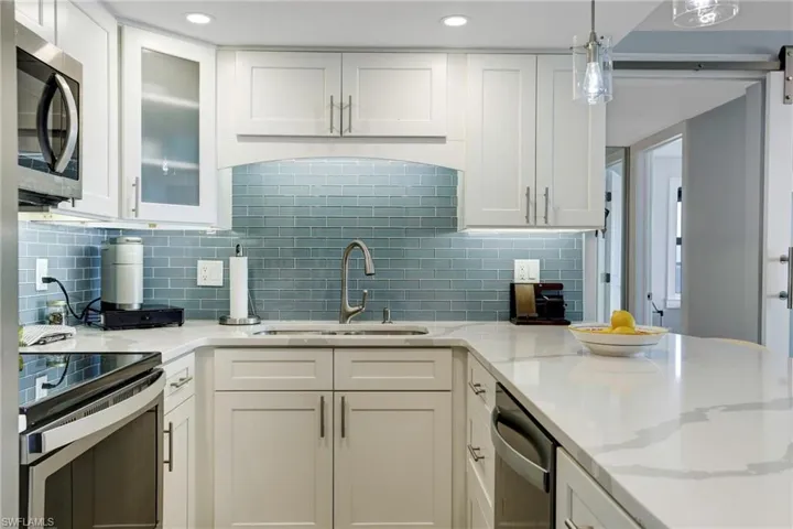 Kitchen featuring white cabinetry, appliances with stainless steel finishes, sink, and tasteful backsplash