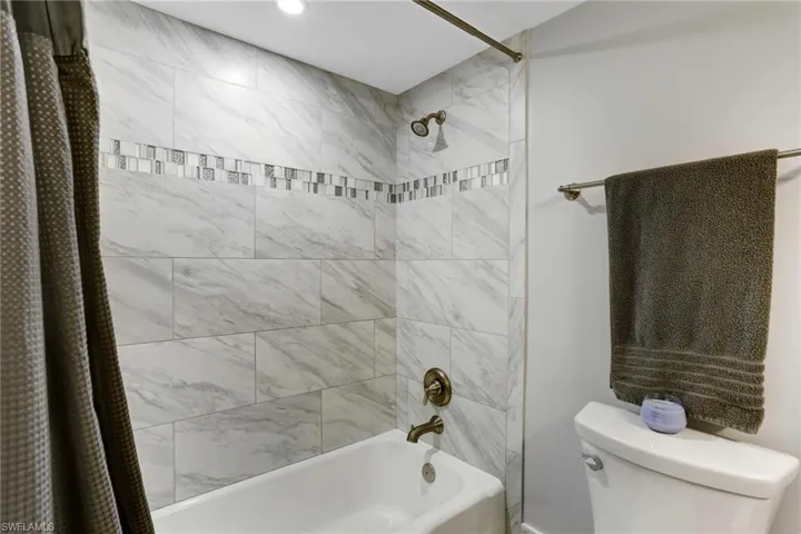 Bathroom featuring shower / tub combo and toilet