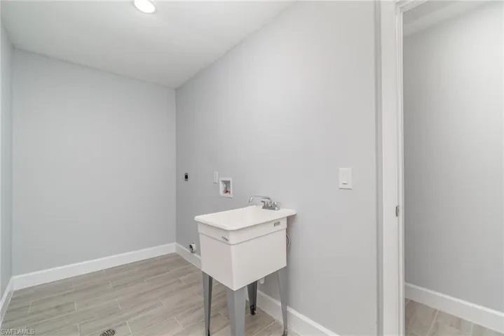 Washroom featuring washer hookup, hookup for an electric dryer, and wood finish floors