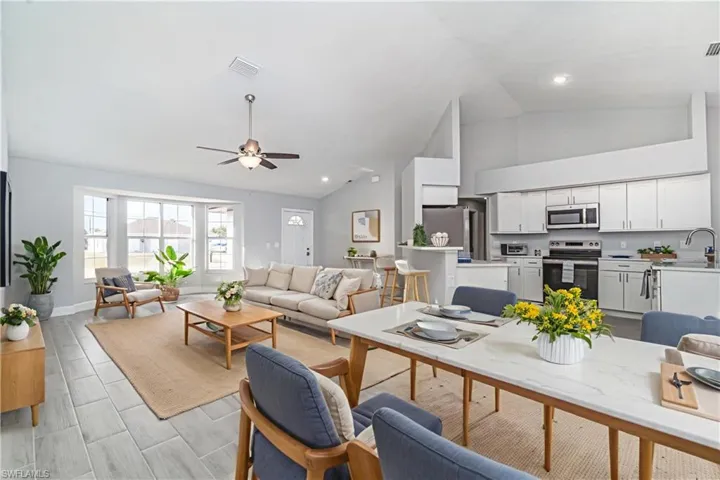 Living room with a ceiling fan, recessed lighting, and high vaulted ceiling