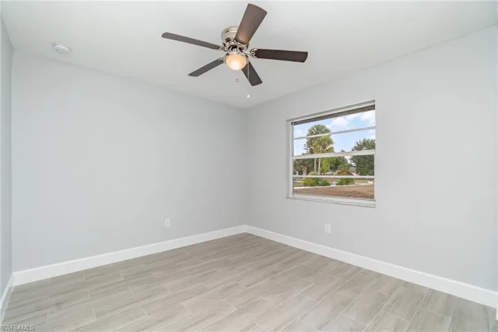 Unfurnished room with wood finish floors and ceiling fan