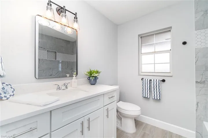 Full bathroom featuring vanity and a marble finish shower