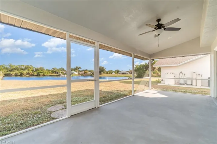 Unfurnished sunroom with a water view, a ceiling fan, and vaulted ceiling