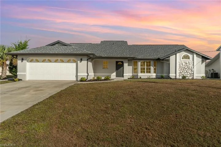 Ranch-style home featuring concrete driveway, an attached garage, a porch, roof with shingles, and a yard