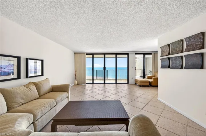Expansive living area with large format tile flooring extending to a private balcony