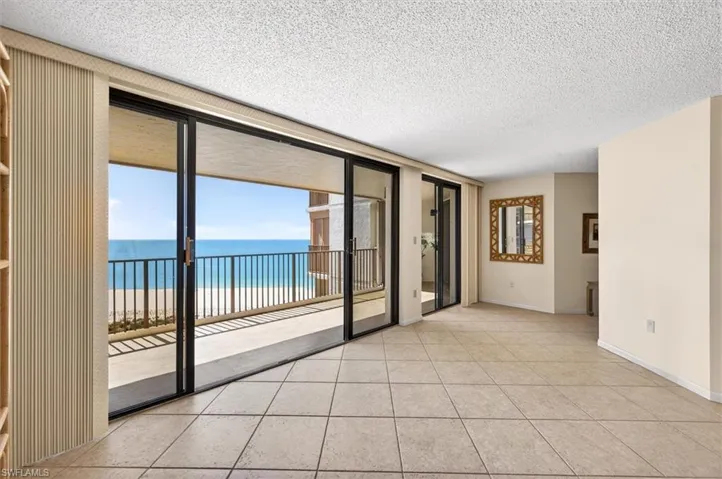 Expansive living area with large format tile flooring and direct access to a private balcony