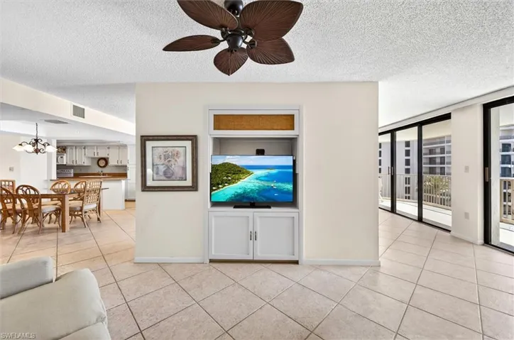 Open-concept living area with large format tile flooring and a built-in entertainment center