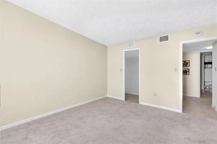 Neutral tone wall finishes with plush carpet flooring