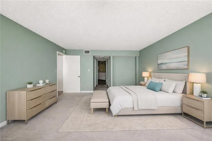 Spacious room featuring muted green walls and light-colored carpeting