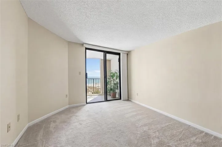 Spacious interior featuring neutral carpeting, light-toned walls, and a textured ceiling
