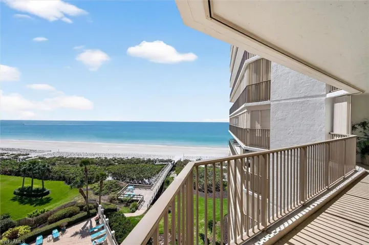 Expansive balcony with light-toned railings, offering direct beachfront access
