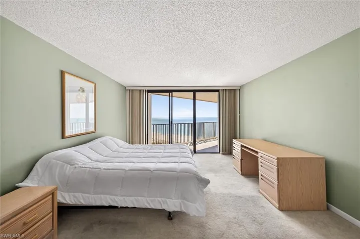 Room featuring sliding glass doors opening to a balcony with ocean views