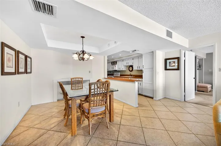 Dining area featuring large format tile flooring and a tray ceiling