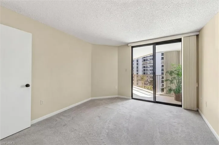 Room featuring light beige walls, textured ceiling, and grey carpeting