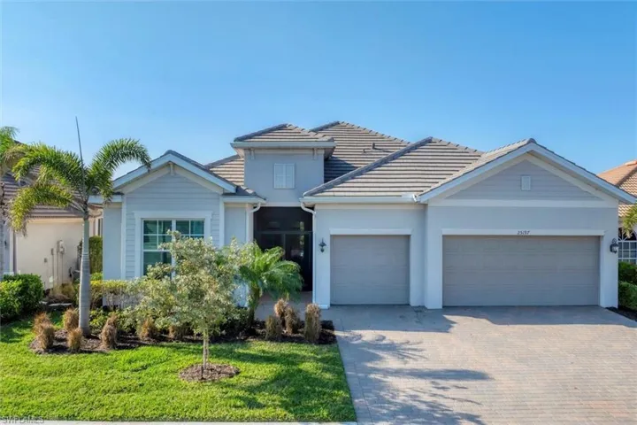 View of front of property featuring a garage and a front yard