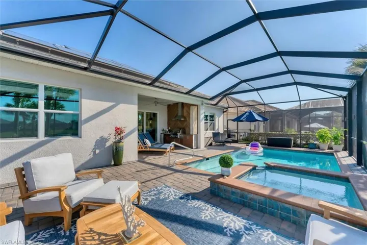 View of swimming pool featuring an in ground hot tub, ceiling fan, a patio, and glass enclosure
