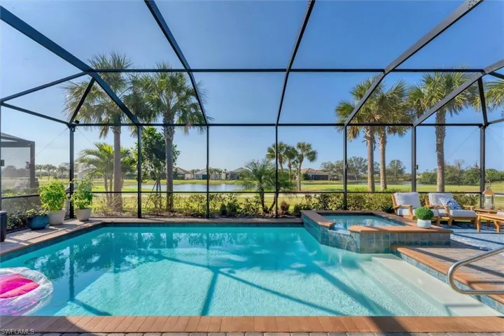 View of swimming pool featuring a water view, an in ground hot tub, a lanai, and a patio area
