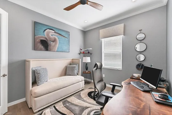 Home office featuring crown molding, wood-type flooring, and ceiling fan