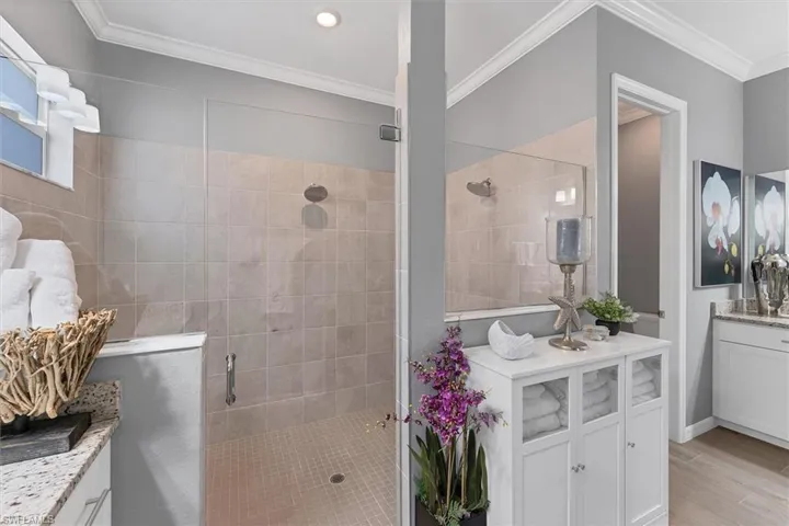Bathroom with an enclosed shower, crown molding, wood-type flooring, and vanity