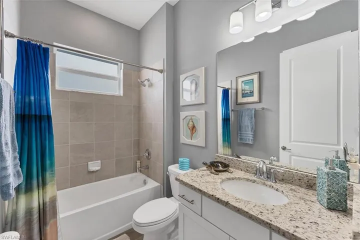 Full bathroom featuring shower / bath combo, vanity, and toilet