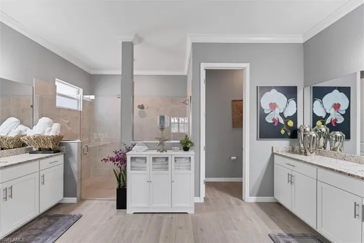 Bathroom featuring hardwood / wood-style floors, ornamental molding, and a shower with door