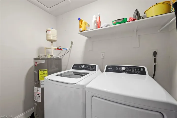 Laundry room featuring washer and clothes dryer and water heater