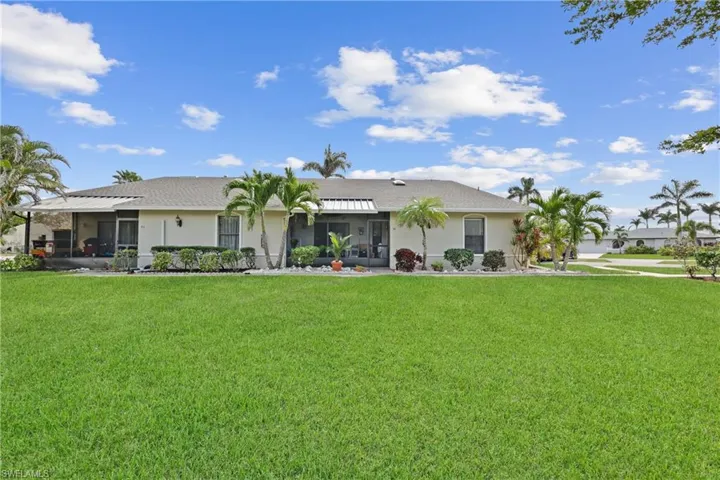Back of property with a lawn and a sunroom