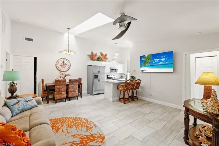 Living room with sink and ceiling fan with notable chandelier