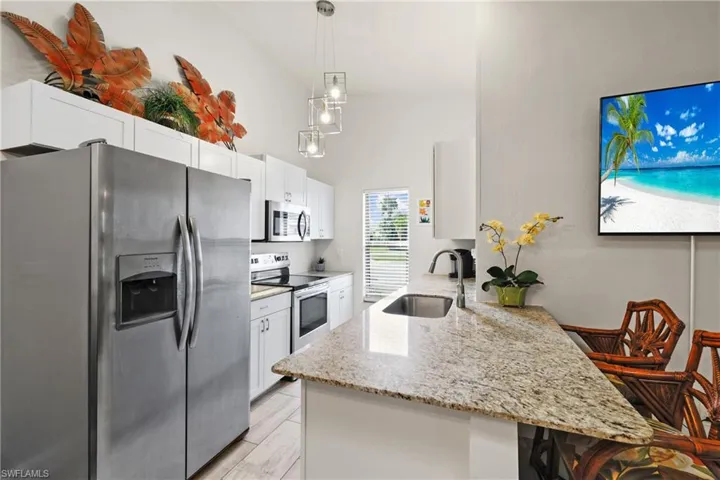Kitchen featuring stainless steel appliances, sink, white cabinets, and kitchen peninsula