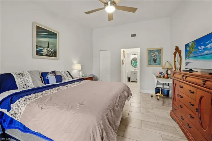 Bedroom featuring ensuite bath and ceiling fan