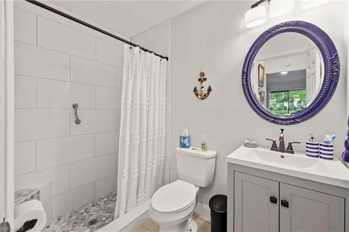 Bathroom featuring vanity, toilet, and a shower with shower curtain