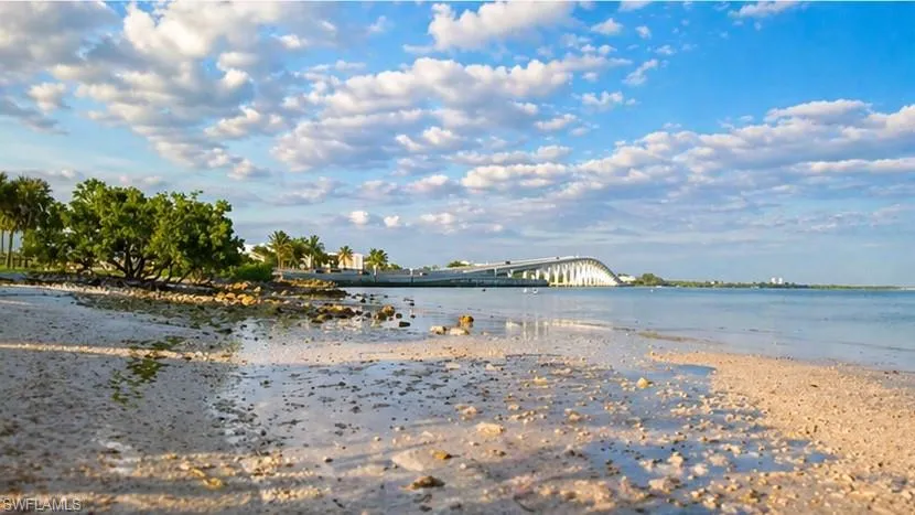 Sandy shoreline featuring natural rocks and mature coastal vegetation
