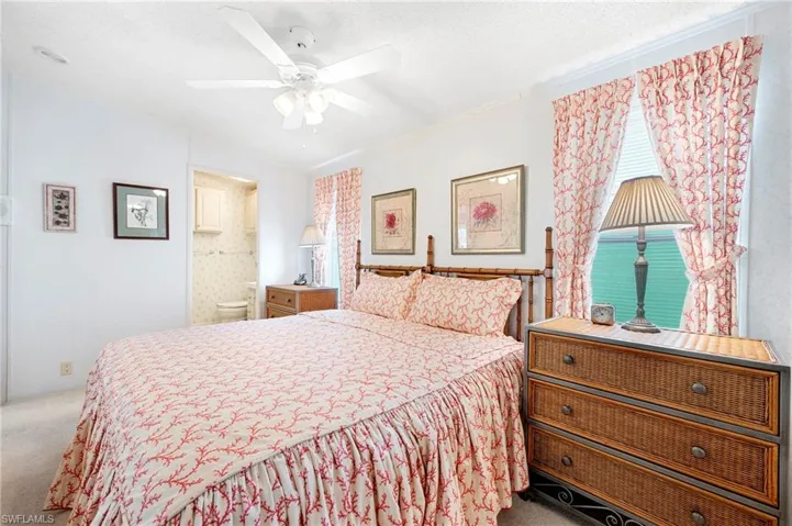 Bedroom with carpet, ensuite bathroom, and a ceiling fan