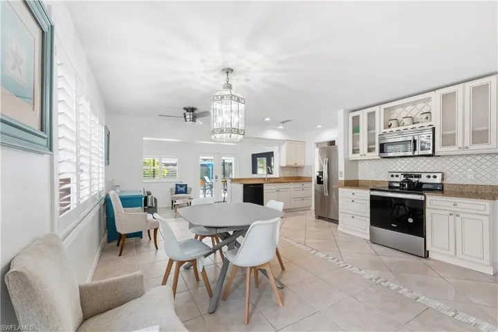 Dining space with light tile patterned floors, recessed lighting, and a chandelier