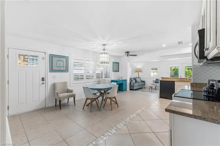 Dining area with light tile patterned floors, ceiling fan, and recessed lighting