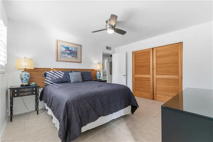 Bedroom with light tile patterned floors, a ceiling fan, and a closet
