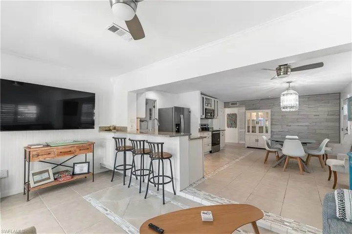 Living area with a ceiling fan and light tile patterned floors