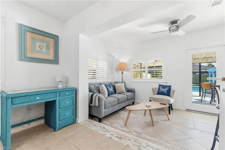 Living area with light tile patterned floors and ceiling fan