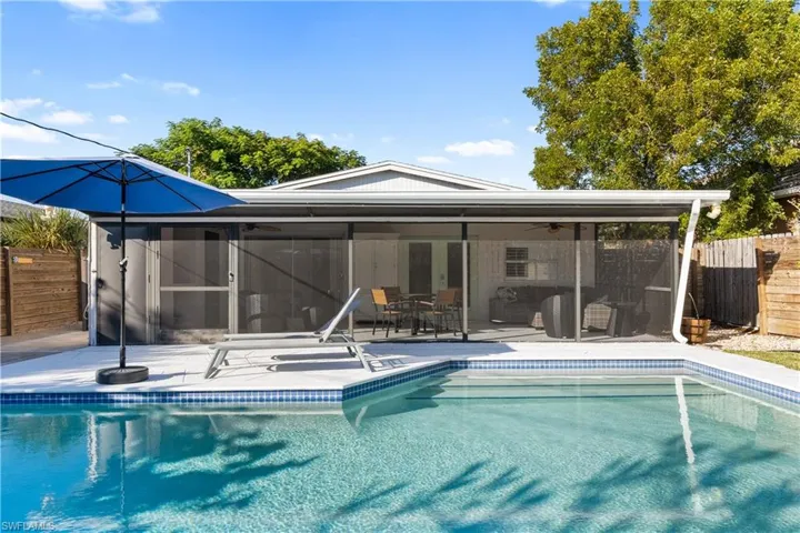 Rear view of property featuring ceiling fan, an outdoor pool, a sunroom, and a patio