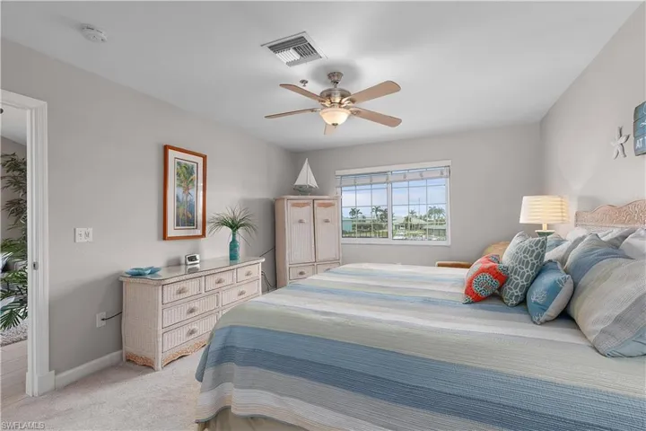 Bedroom with light carpet and a ceiling fan