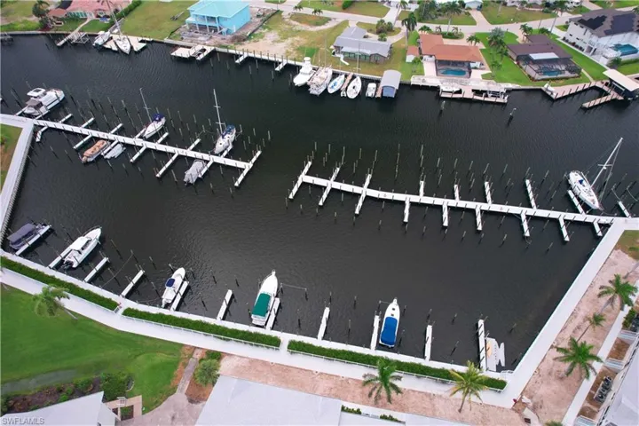 Aerial overview of property's location with a nearby body of water and a marina